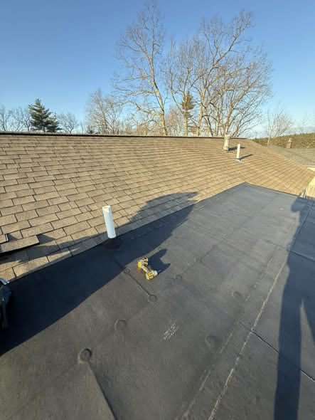 Flat roof meeting a shingle roof